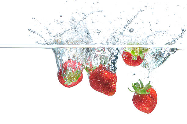 Strawberry falling in water stock photo