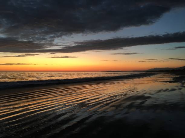 vagues noires au coucher du soleil - tide energy water textured photos et images de collection
