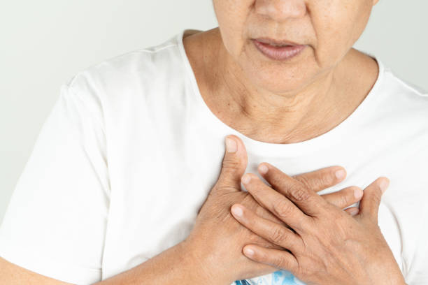 istock Old woman heart attack holding breast on white background 1210897615