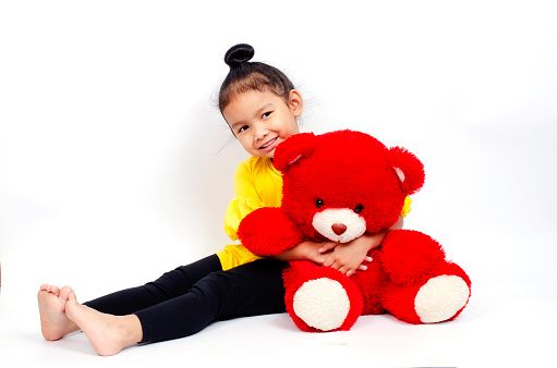 Cute asian girl with red teddy bear on white backgrounds studio lights