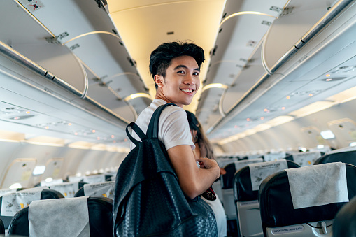 retrato de joven viajero varón asiático a bordo de un avión photo