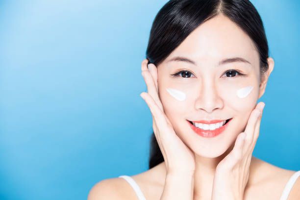 istock woman apply lotion on face 1210902804