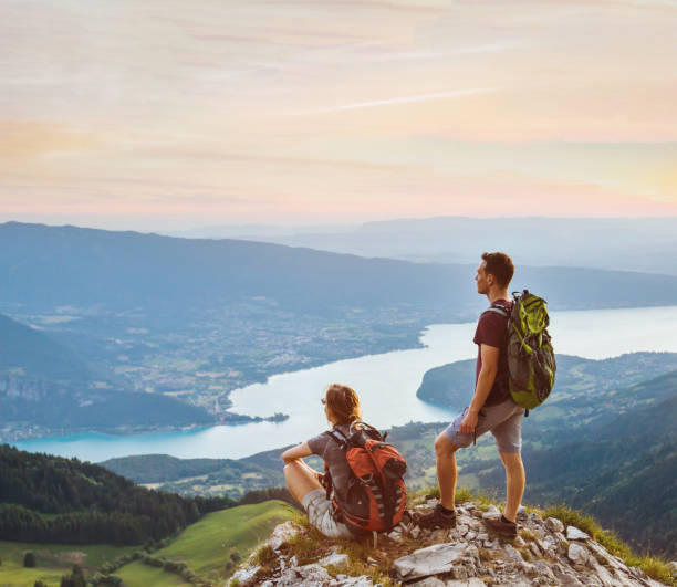 couple de randonneurs se détendre au sommet de la montagne avec une belle vue panoramique à l’extérieur, deux touristes - european alps women summer outdoor pursuit photos et images de collection