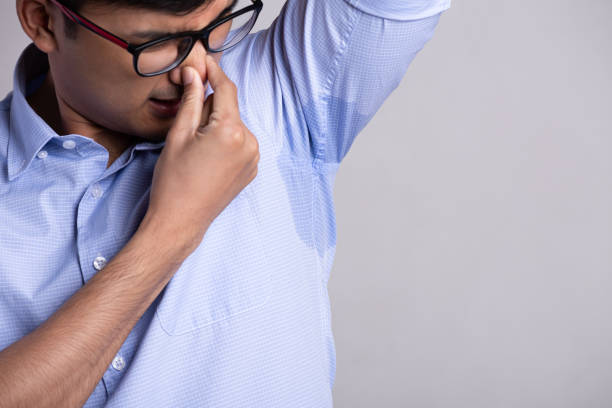 istock Close up asian man with hyperhidrosis sweating. Young asia man with sweat stain on his clothes against grey background. Healthcare concept. 1210908923