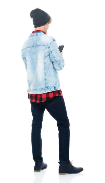 istock Caucasian young male hipster standing in front of white background wearing boot and using smart phone 1210910295
