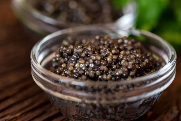 istock Black surgeon or beluga caviar on wooden table 1210913230
