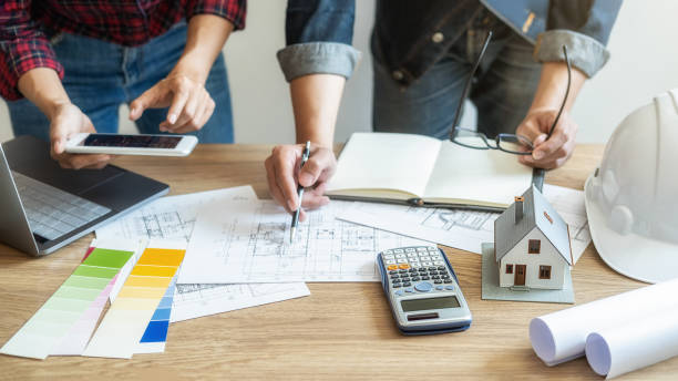 istock Interior designer and Architect choosing color in color swatch samples chart for house coloring selection in office with blueprint. Construction concept. 1210913634