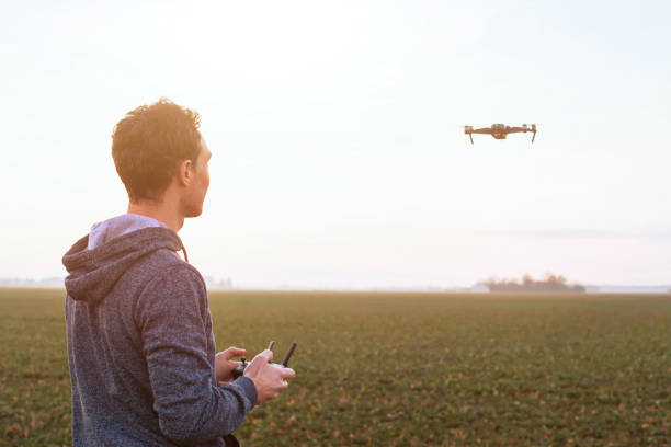 uomo pilotando drone - pilotando foto e immagini stock