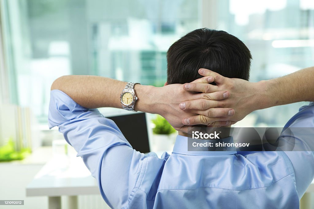 Short break Back view of businessman having break in office Adult Stock Photo