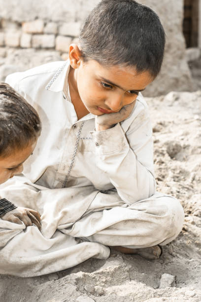 istock adorable helpless refugee brother and sister are sleeping on a muddy surface 1210923927