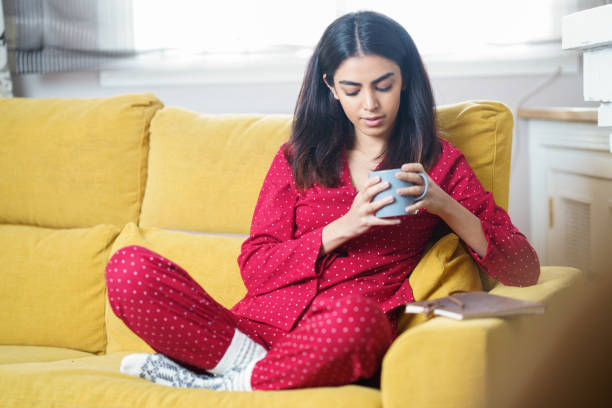 istock Woman at home having tea and reading 1210924905