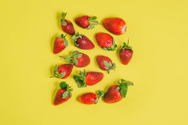 istock Fresh strawberries on a colored background. Group of large red berries on a yellow background. 1210925103