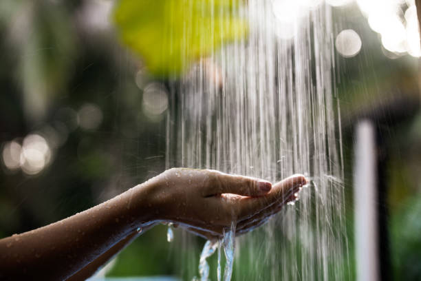 자연에서 샤워 아래 그녀의 손을 잡고 인식 할 수없는 여자의 가까이. - shower women water outdoors 뉴스 사진 이미지