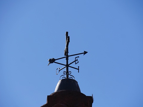 Rotating compass on top of an old building.