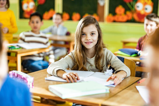istock Happy schoolgirl paying attention on a class in the classroom. 1210926997
