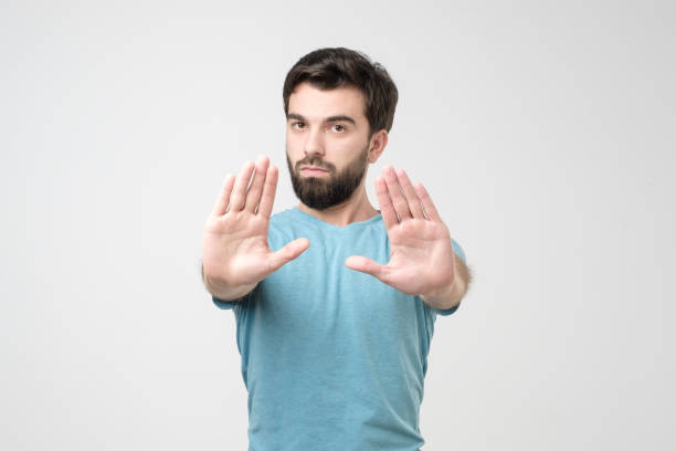 istock Handsome hispanic man making stop sign refusing to take the award. 1210930587