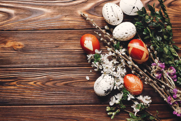 istock stylish easter eggs with white flowers and buds on wooden background flat lay. modern eggs and natural dyed with herbs,  willow buds top view. space for text 1210937126