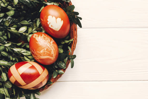istock stylish easter eggs on green leaves on white wooden background flat lay. modern eggs natural dyed with herbs, top view. space for text. happy easter greeting 1210939216