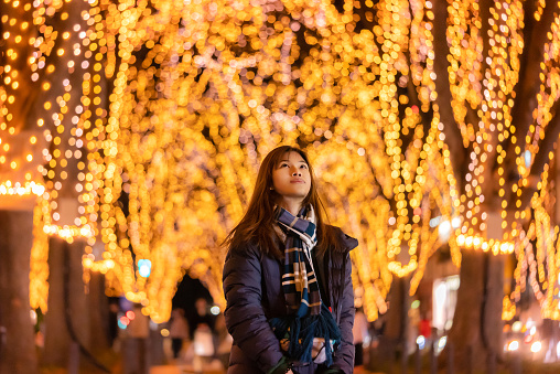 Beautiful Woman portrait in winter clothing at night in The Jozenji christmas light up festival in Sendai, Japan