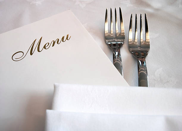 Menu on the table near two forks stock photo