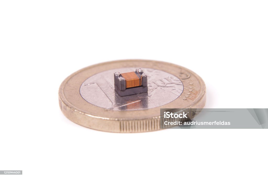 Tiny common mode choke filter in comparison with 1 euro coin High integrity electronics component common mode choke Coin Stock Photo