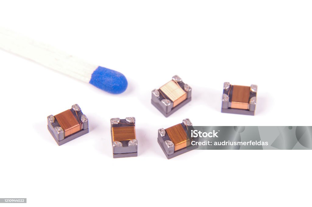 Tiny common mode choke filter in comparison with match head High integrity electronics component common mode choke Comparison Stock Photo