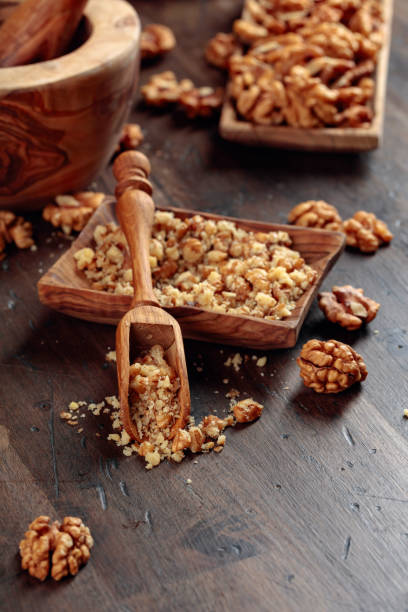 istock Walnuts in a wooden dish on an old wooden table. 1210944980