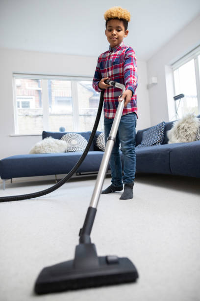 istock Boy Helping Out With Chores At Home Vacuuming Carpet In Lounge 1210945794