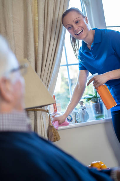 istock Female Home Help Cleaning House For Senior Man 1210945877