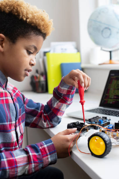 理科レッスンで男性小学校の生徒構築ロボット車 - elementary school building ストックフォトと画像