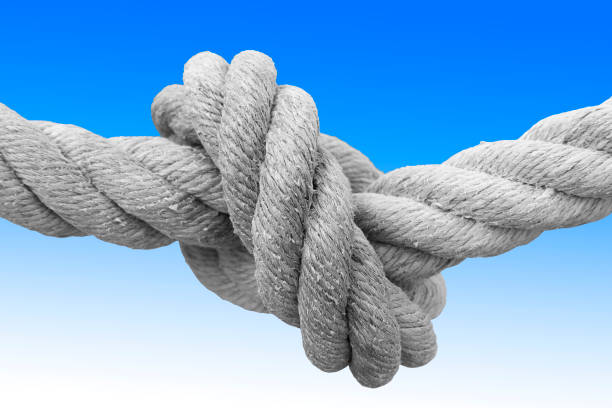 istock Strong rope with single knot - concept image against a blue and white background 1210945938