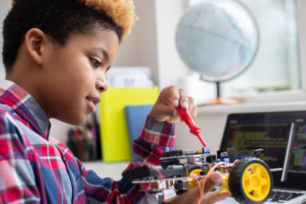 istock Male Elementary School Pupil Building Robot Car In Science Lesson 1210945952