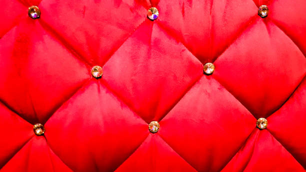istock back of a red sofa. Red fabric texture background, Chesterfield style decoration with buttons, retro fabric. Retro diamond-shaped soft style fabric decorate with buttons. red velvet background 1210946113