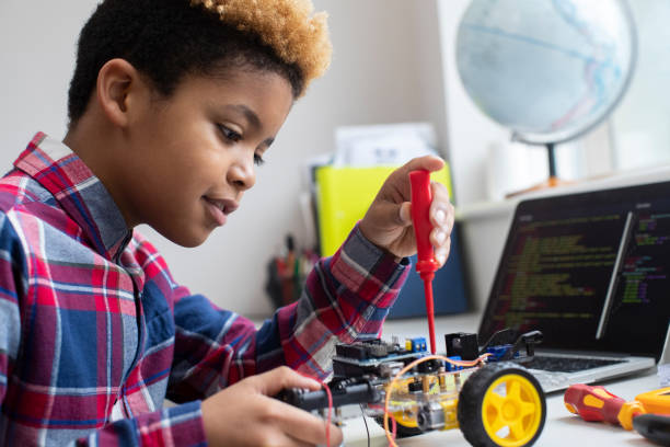 istock Male Elementary School Pupil Building Robot Car In Science Lesson 1210946156