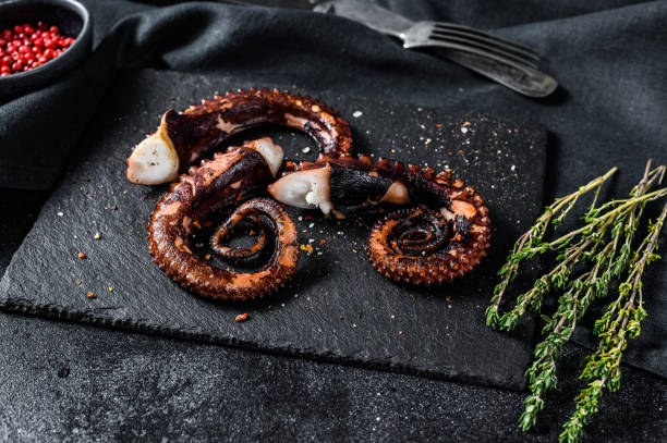 istock Grilled octopus tentacles. Fresh seafood. Black background. Top view 1210947479