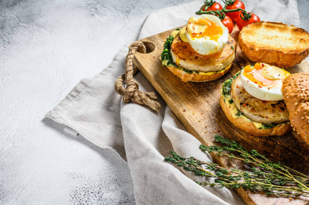 istock Healthy fresh seafood burger with fish fillet, spinach and egg.  Gray background. Top view. Copy space 1210947544
