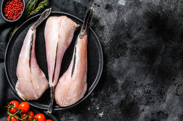 istock Separate fresh monkfish without head and skin. Black background. Top view. Copy space 1210948471