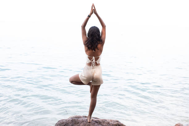 istock Young woman doing yoga on the beach 1210951158