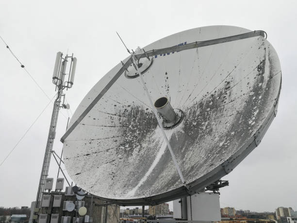 Satellite parabolic dish antenna on the roof for high speed internet link Huge retro satellite parabolic dish antenna on the roof for high speed internet link in front of overcast sky parabola stock pictures, royalty-free photos & images