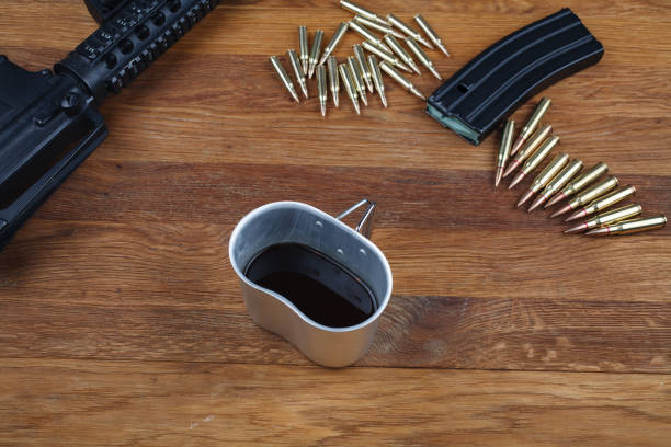 istock assault rifle and cup of coffee on wooden table 1210957169