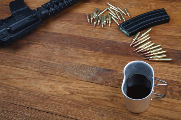 istock assault rifle and cup of coffee on wooden table 1210957174