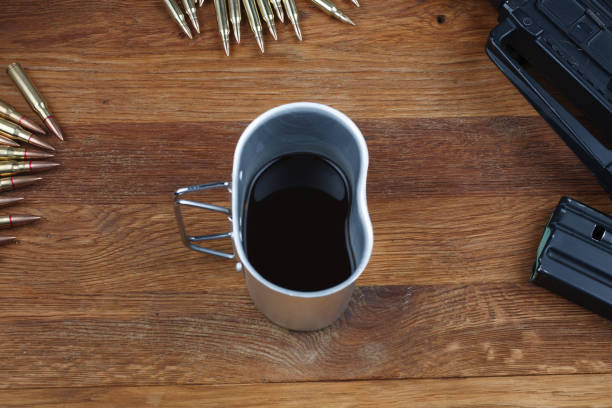 assault rifle and cup of coffee on wooden table