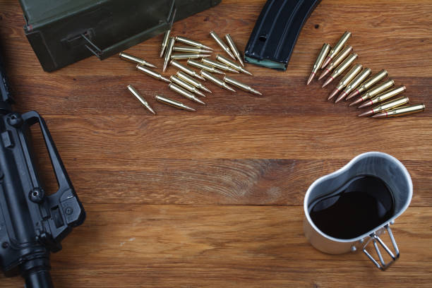 istock assault rifle and cup of coffee on wooden table 1210957448