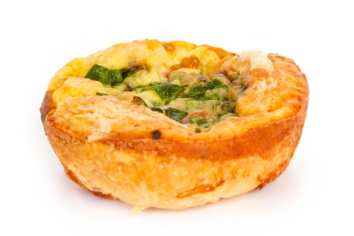 Delicious homemade mini cheese and spinach quiche on white