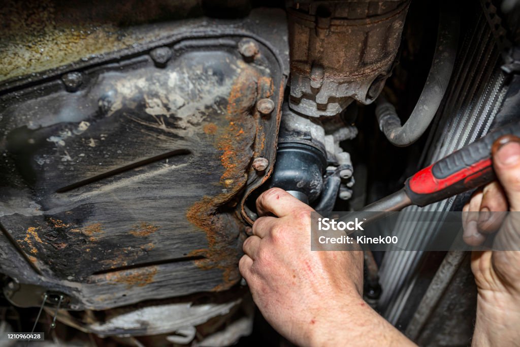 The Car Mechanic Unscrews The Diesel Filter Next To The Oil Pan With A  Metal Wrench Visible Man Hands Stock Photo - Download Image Now - iStock