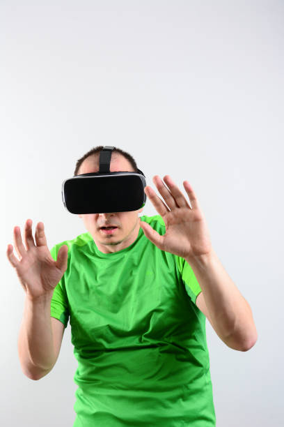 istock Front view of Young man looking into vr headset. Isolated on white. Wearable technology concept. 1210961766