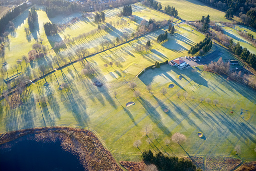 Aerial view of links golf course during summer showing green and bunkers at driving range club house uk