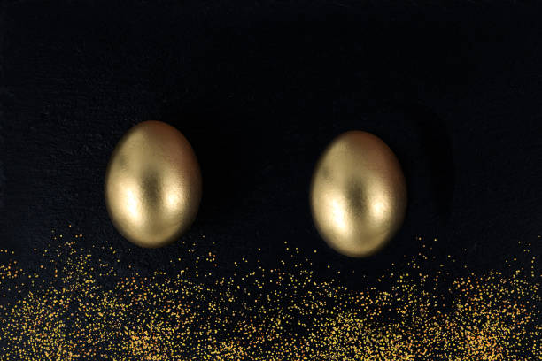 istock Minimal gold eggs easter concept. Golden eggs with golden shine decorated confetti for banner, greeting card, social media advertise on black stone. Flat lay trendy easter greeting card copy space 1210967400