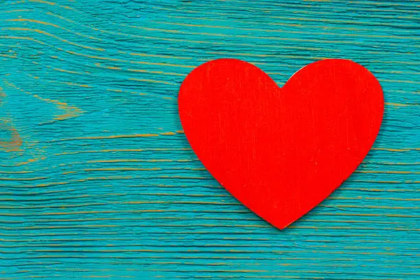 red wooden heart shape on turquoise rustic planks