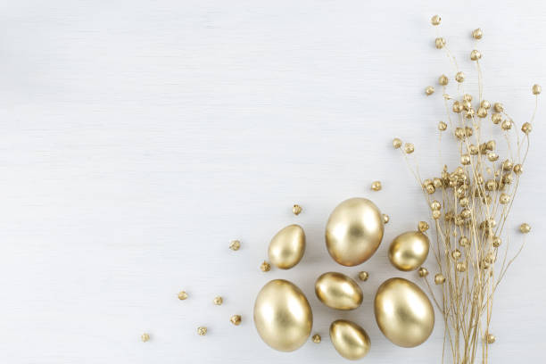 istock Minimal gold eggs easter concept. Stylish easter golden and black eggs with dried golden flax linum bunch on white wooden background. Flat lay trendy easter. Happy easter card with copy space for text 1210967961